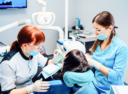 dentist-operating-patient-surgery-office-female-professional-dentist-assistant-treating-woman-patient-clinic-office-with-modern-tools-equipment 2